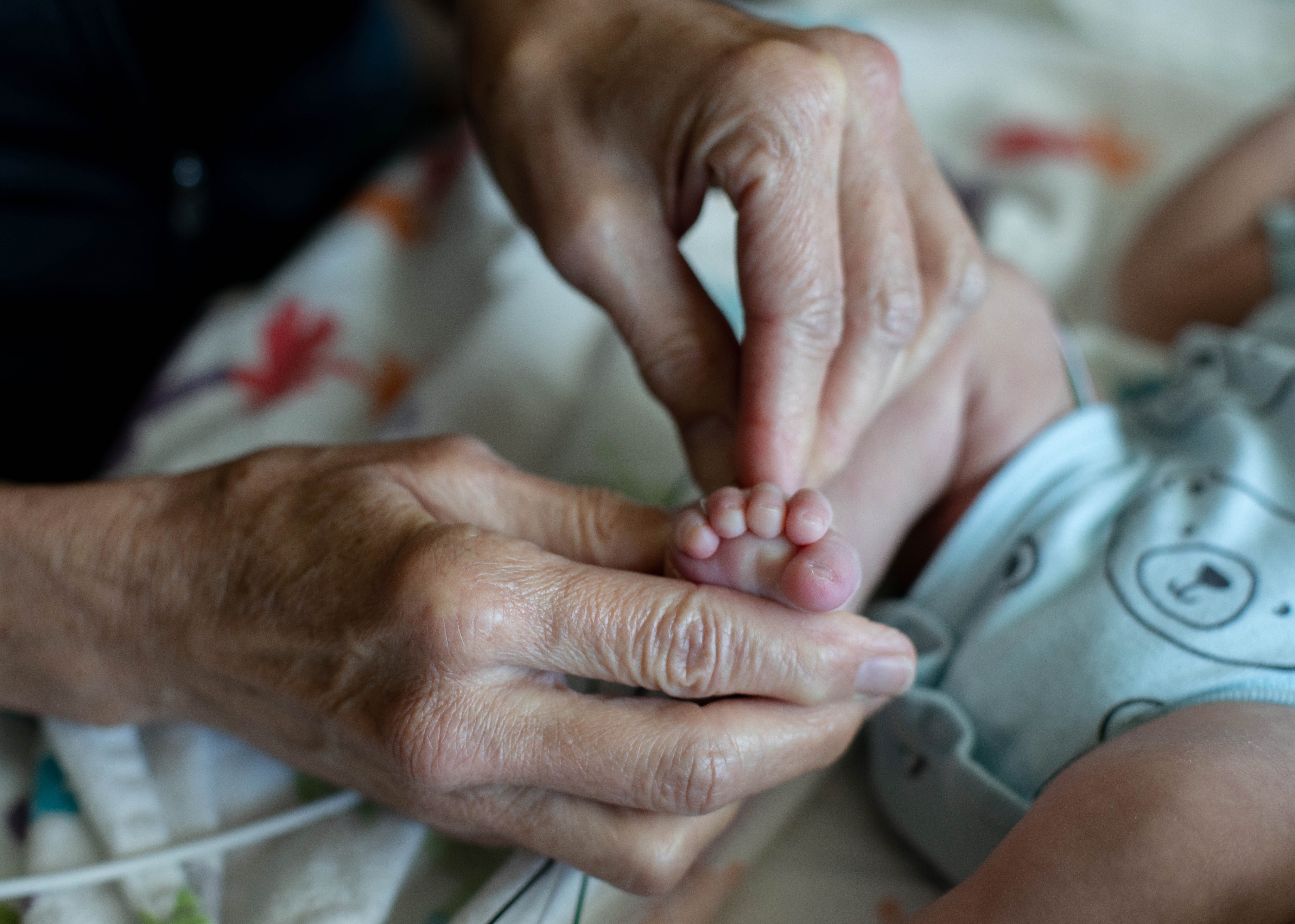 A physician holds the feet of a newborn.