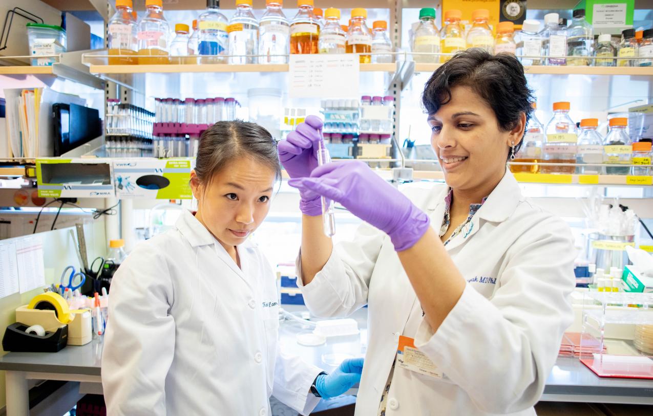 Two lab technicians examine a sample