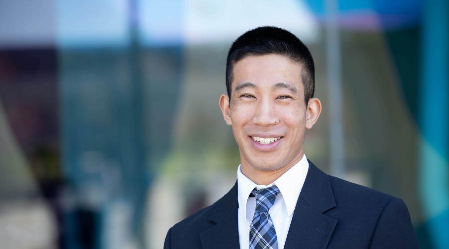 Jason Nagata smiling next to a glass building 