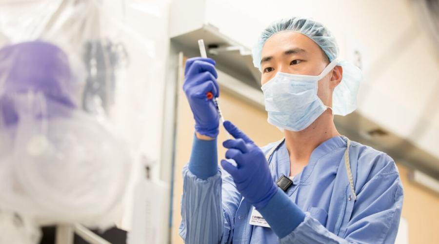 A physician prepares a syringe