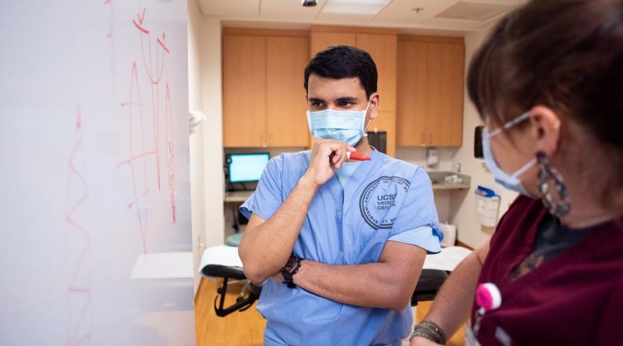 A medical student looks at a whiteboard