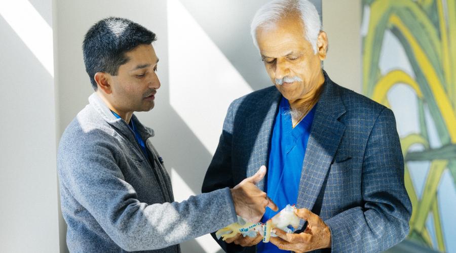 Dr. Shafkat Anwar (left) discusses a 3D printed heart model with Dr. Mohan Reddy, pediatric heart surgeon