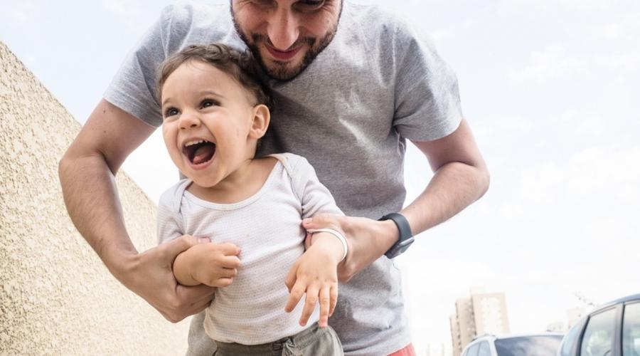 A boy and his father play and laugh.