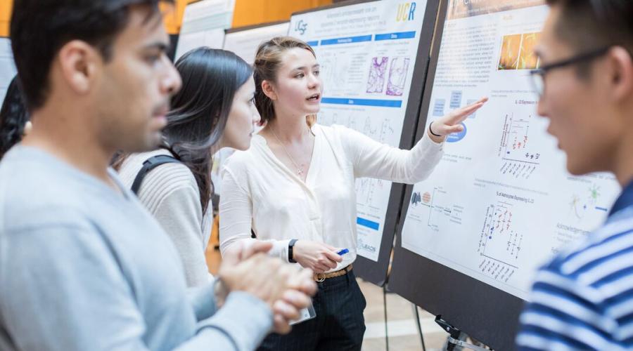 Olga Vafaeva, center, a former student in UCSF's Summer Research Program, explains her poster.