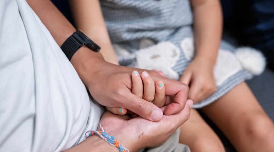 A man holds his daughters hand after a successful stem cell transplant. Photo by Susan Merrell. 