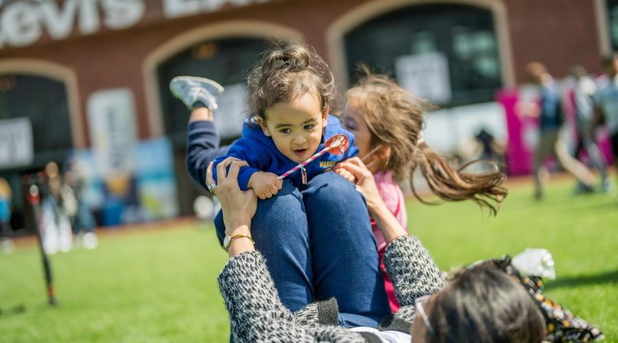 Isabella Torres, 15 months-old, playing with Flores Statum out on the field during the Bay Area Science Festival's Discovery Day at Oracle Park. Photo by Maurice Ramirez