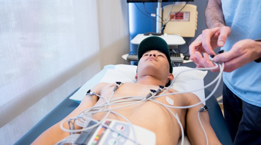 A high school student is given an EKG as part of his physical exam for the Play Safe program. 